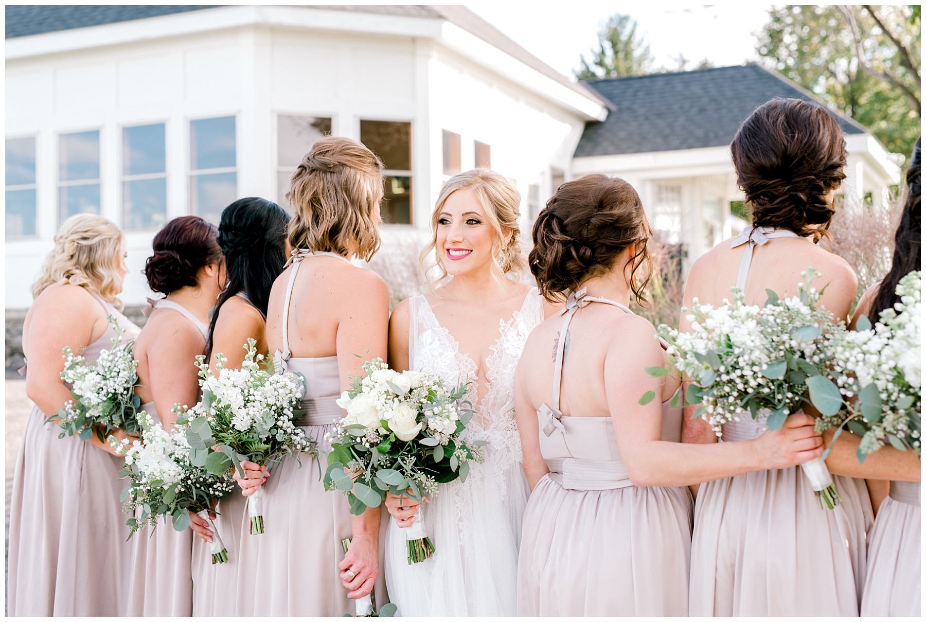 bride facing the camera and bridesmaids facing away with their bouquets at white eagle golf club