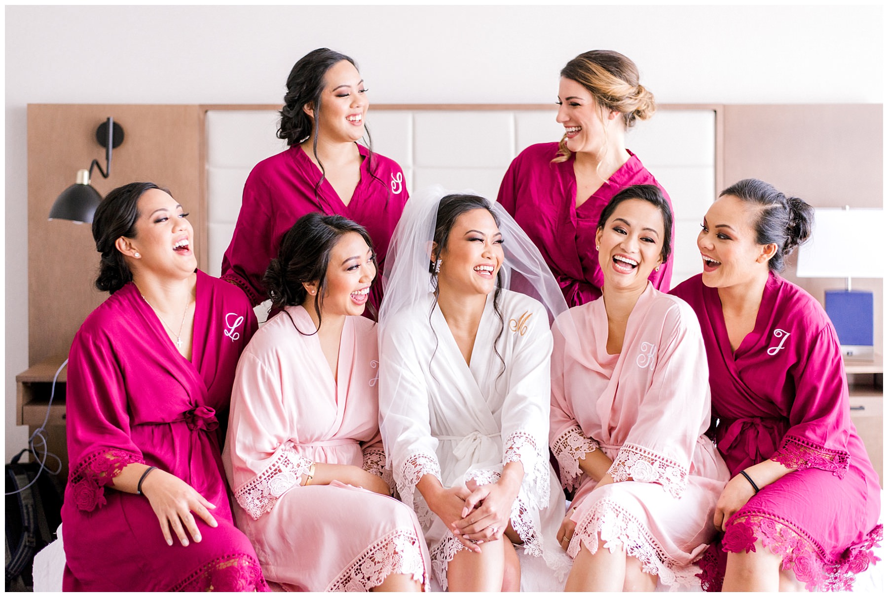 bride and bridesmaids wearing matching robes laughing at each other in chicago downtown